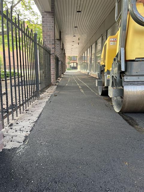 New asphalt pathway paved along a fence line in Ottawa