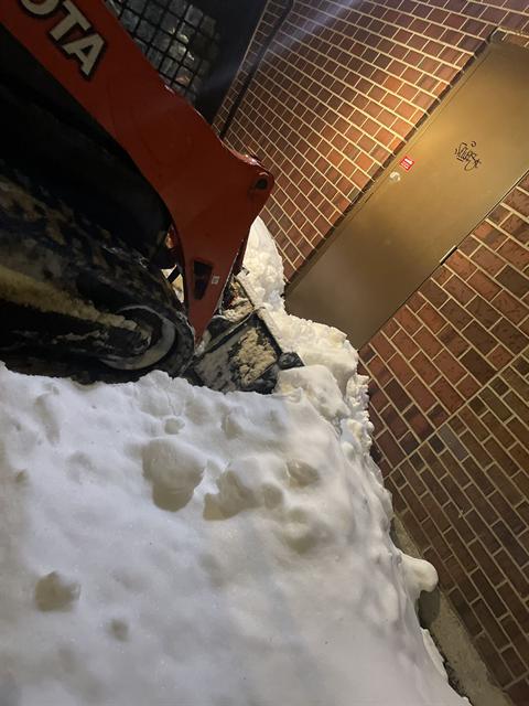 Skid steer clearing snow from a commercial property in Ottawa