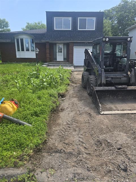 Skid steer excavating and grading a driveway base in Ottawa
