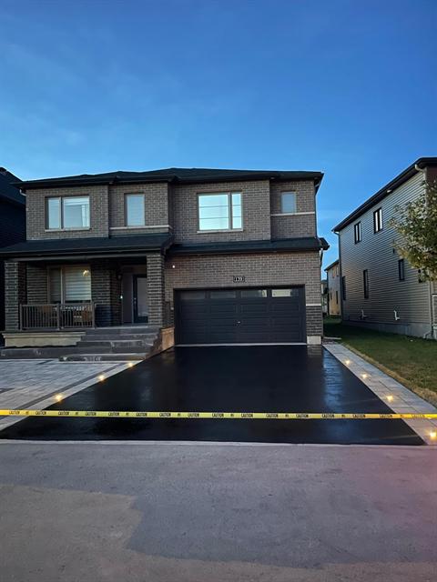 Freshly sealed asphalt driveway at dusk in Ottawa