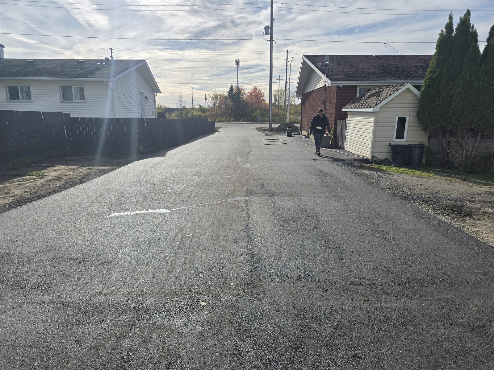 Wide freshly paved asphalt laneway between homes in Ottawa