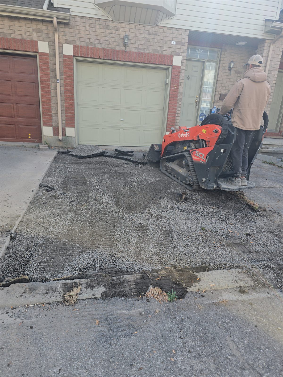 Kubota track loader removing old asphalt for a driveway repair in Ottawa