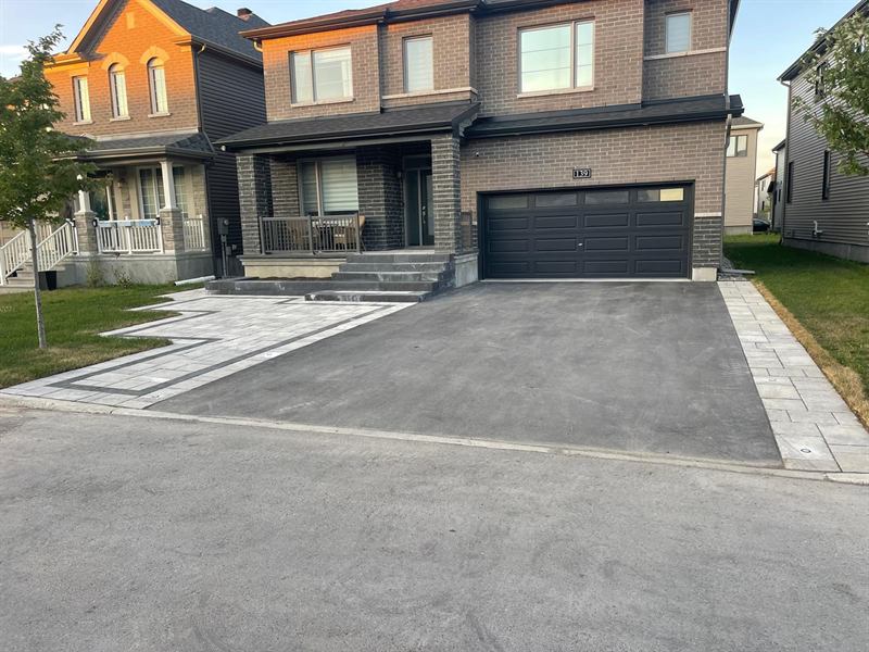Asphalt driveway finished with an interlock paver border at an Ottawa townhome