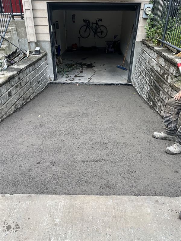 New asphalt driveway laid between stone retaining walls at an Ottawa home