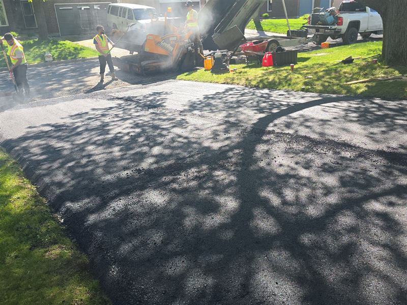 Proseal Plus crew laying hot-mix asphalt with a paver on an Ottawa driveway