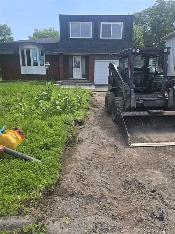 Skid steer excavating a driveway base at a home in Ottawa