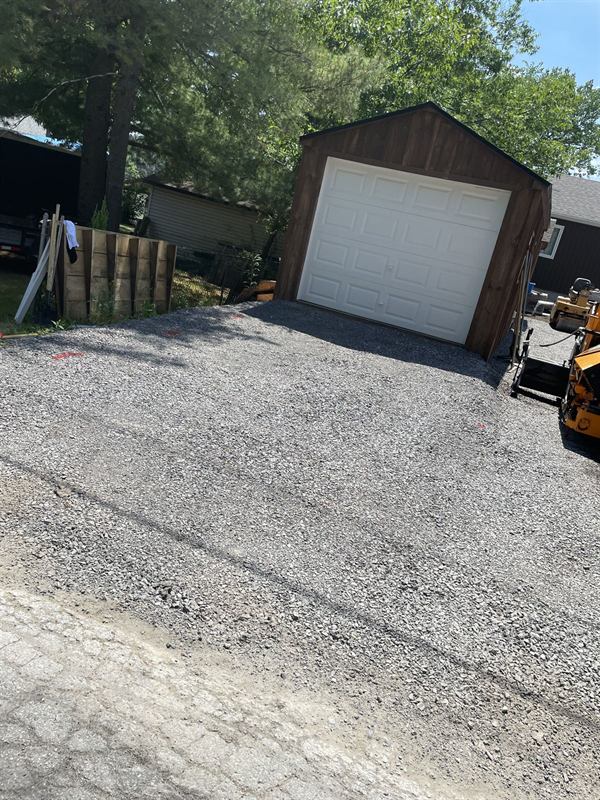 Compacted gravel base prepared for asphalt paving at an Ottawa home