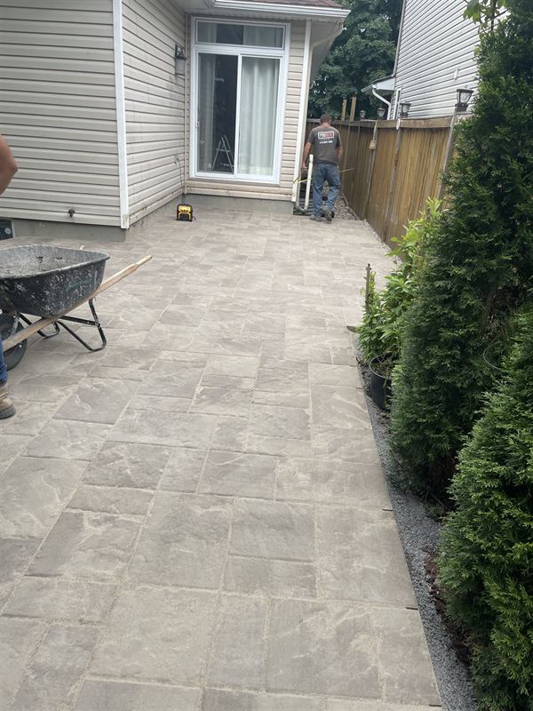Interlocking paver patio being installed in an Ottawa backyard