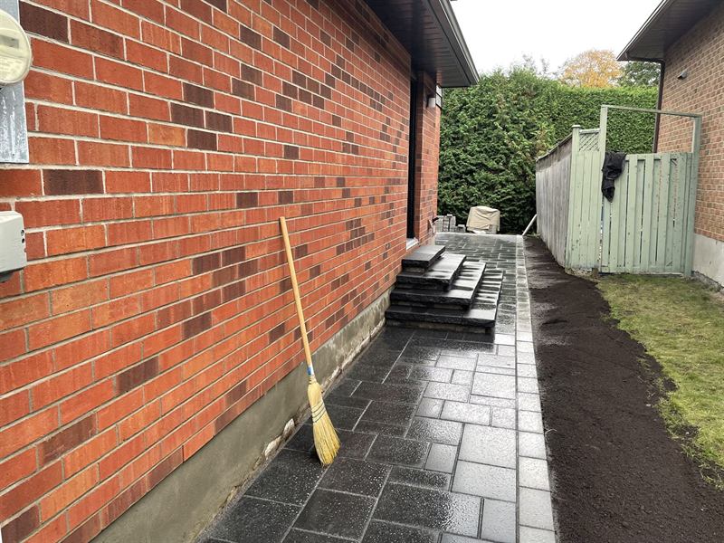Interlocking paver walkway running alongside a brick home in Ottawa
