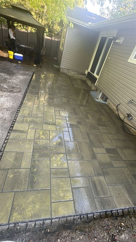 Freshly sealed interlock paver walkway beside a home in Ottawa