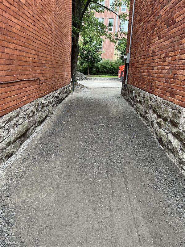 Graded gravel laneway base between two buildings in Ottawa