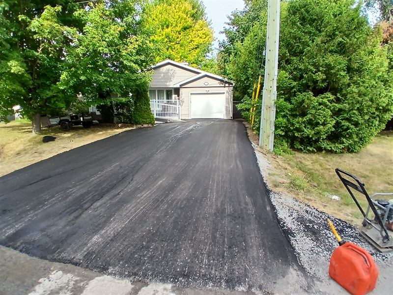 New asphalt driveway running back to a detached garage in Ottawa