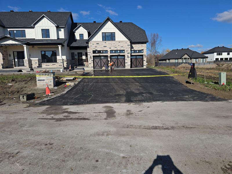 Wide asphalt driveway paved at a new-build stone home in Ottawa