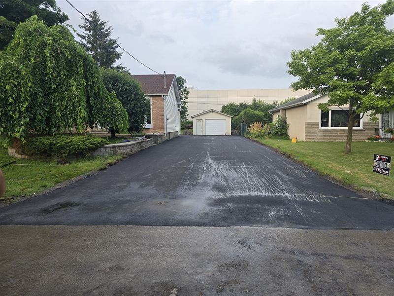 Wide freshly paved residential asphalt driveway in Ottawa